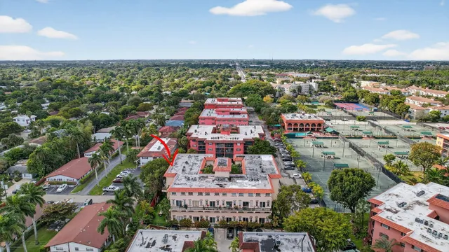 an aerial view of a city with lots of residential buildings ocean and mountain view in back