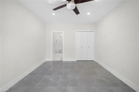 an empty room with closet and windows