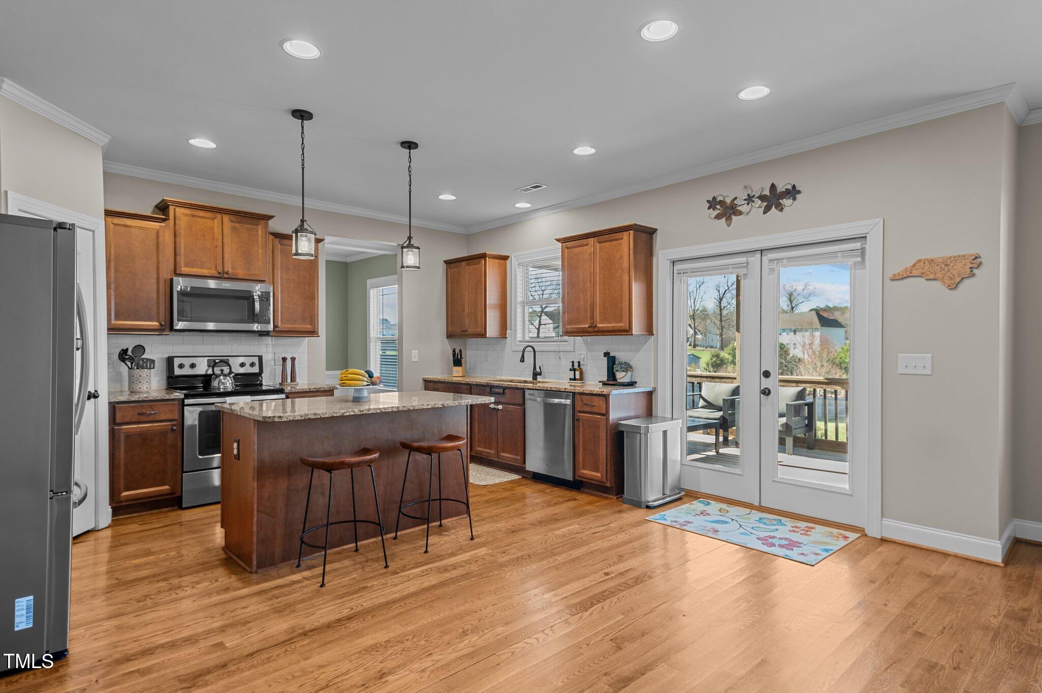 1036 Butterfly Circle Wake Forest, NC 27587 - Photo 24 of 51 a kitchen with stainless steel appliances kitchen island granite countertop a refrigerator stove top oven and sink