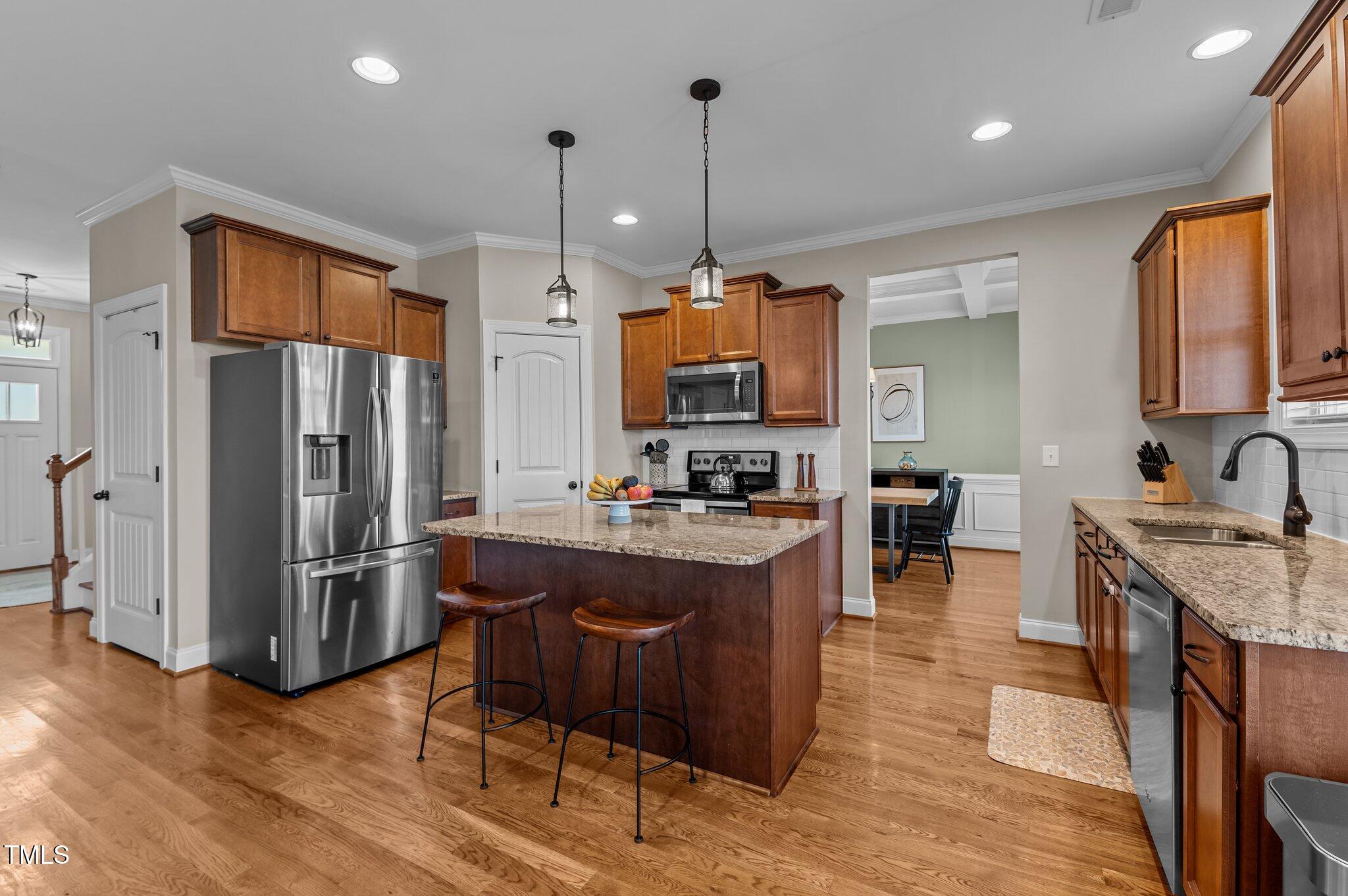 1036 Butterfly Circle Wake Forest, NC 27587 - Photo 26 of 51 a kitchen with stainless steel appliances granite countertop a refrigerator a sink dishwasher a oven and a dining table with wooden floor
