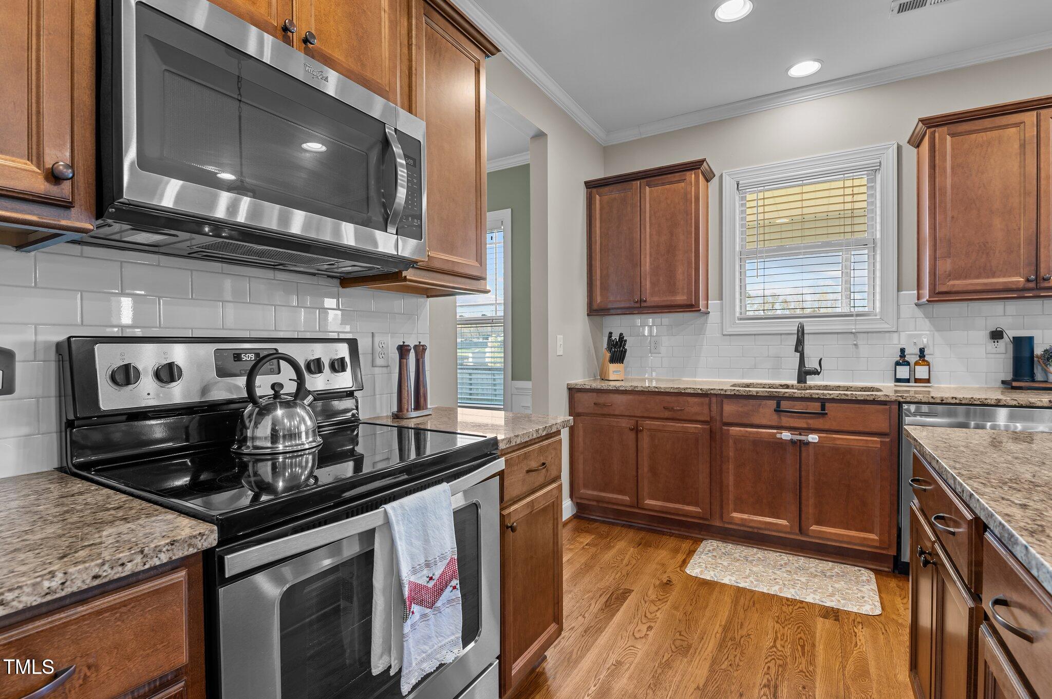 1036 Butterfly Circle Wake Forest, NC 27587 - Photo 32 of 51 a kitchen with stainless steel appliances granite countertop a stove a sink and a microwave