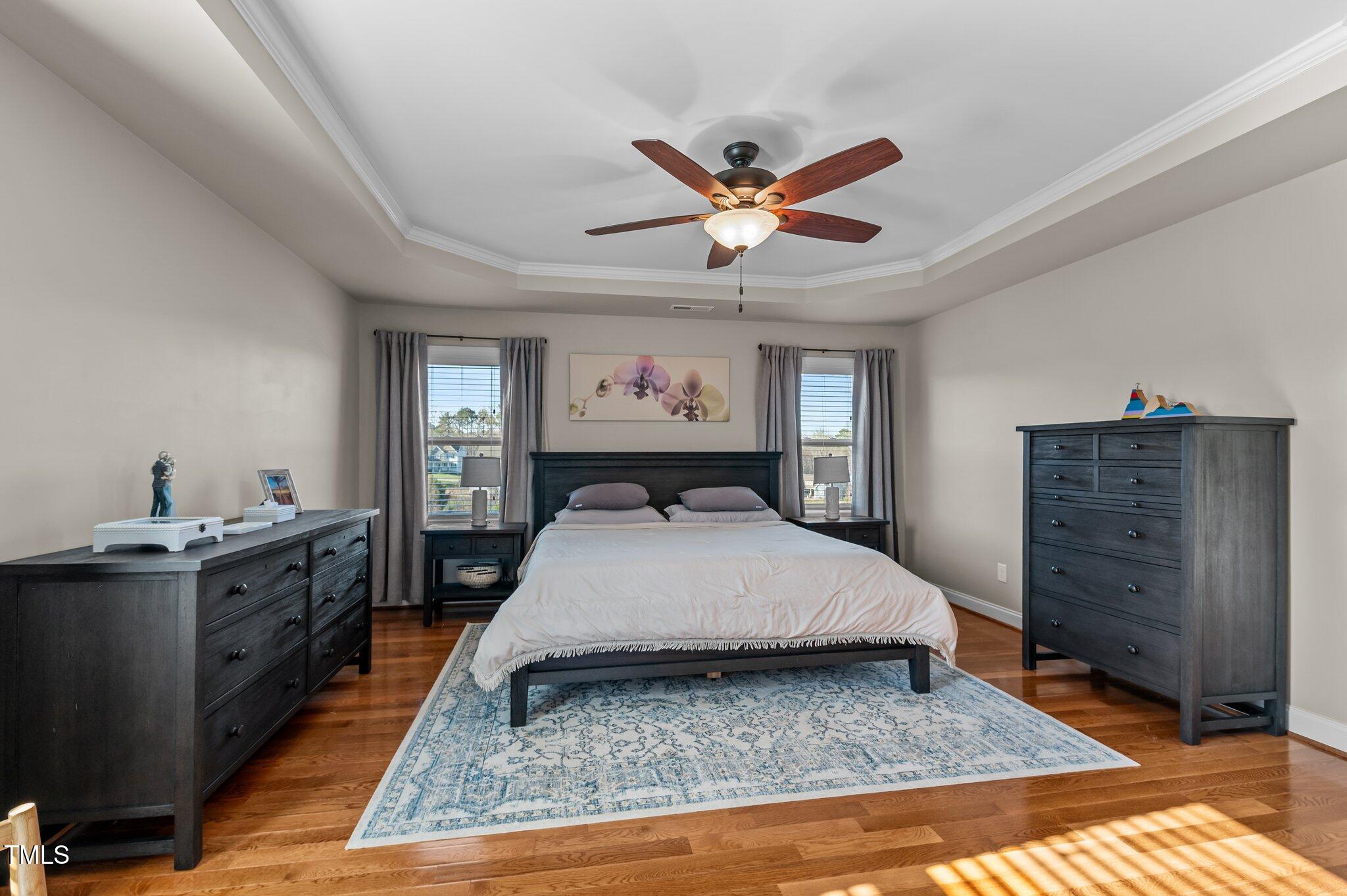 1036 Butterfly Circle Wake Forest, NC 27587 - Photo 40 of 51 a bedroom with a large bed and a chandelier