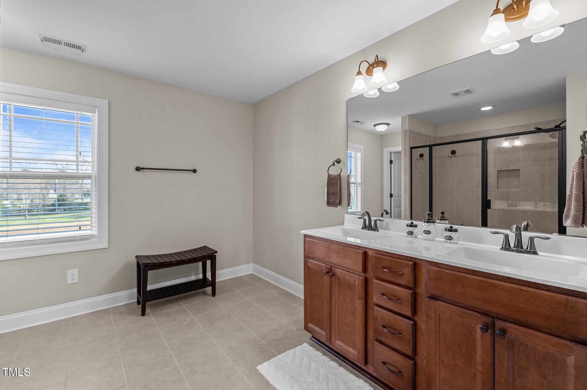 1036 Butterfly Circle Wake Forest, NC 27587 - Photo 41 of 51 a bathroom with double sink and a mirror