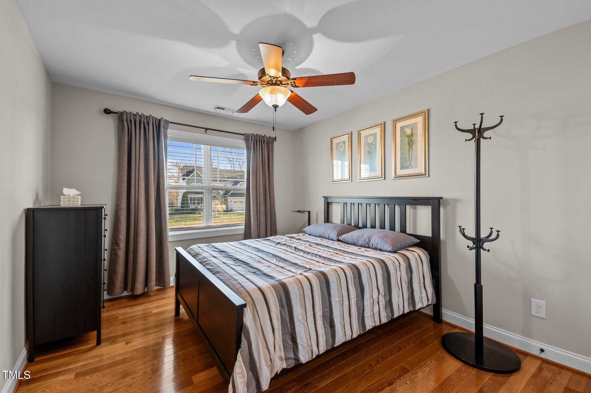 1036 Butterfly Circle Wake Forest, NC 27587 - Photo 50 of 51 a bedroom with a bed and wooden floor