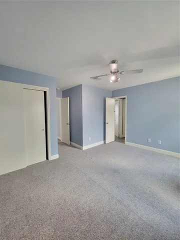 a bathroom with a granite countertop sink a toilet a mirror and shower