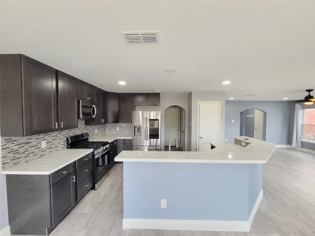 a kitchen with stainless steel appliances a refrigerator and a stove top oven