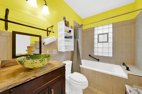 a bathroom with a granite countertop sink a toilet and bathtub