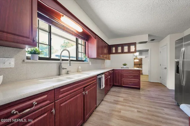 a kitchen with stainless steel appliances granite countertop wooden cabinets a stove top oven a sink and dishwasher