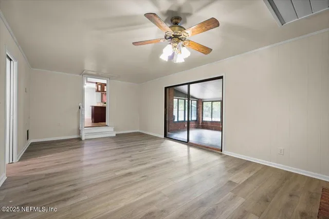 an empty room with a ceiling fan and a window