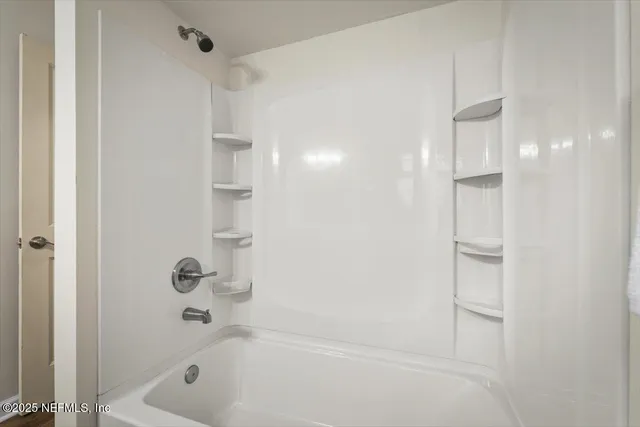 an empty room with a ceiling fan and carpet