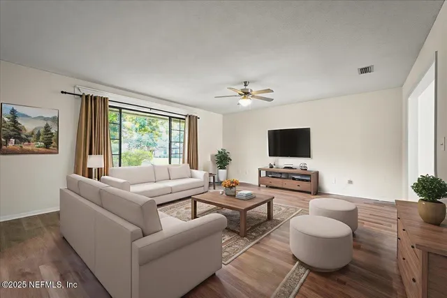 a living room with furniture a wooden floor and a large window
