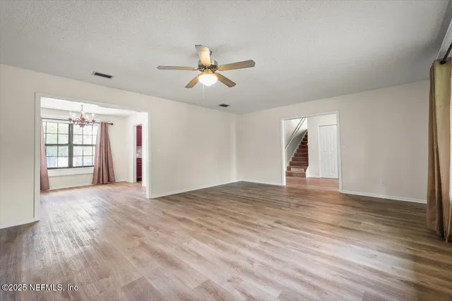 a view of a big room with wooden floor and a chandelier