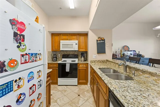 a kitchen with stainless steel appliances granite countertop a sink dishwasher and cabinets with wooden floor