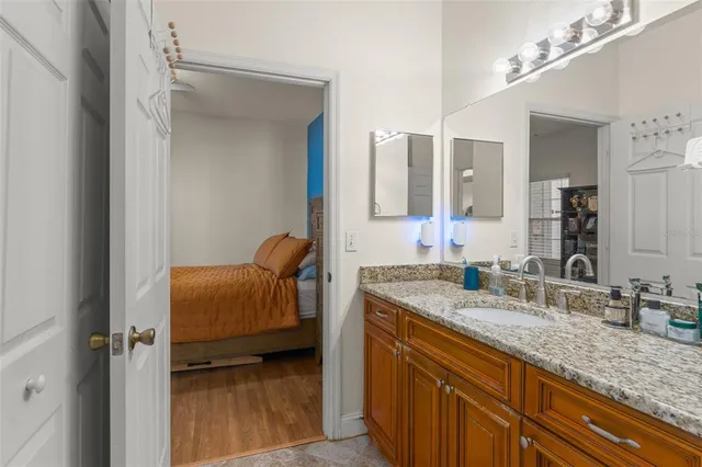 a en suite bathroom with a granite countertop sink and a mirror
