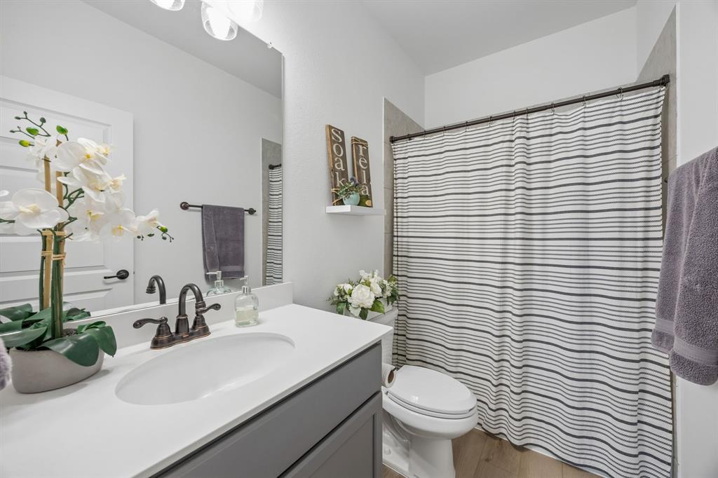 3200 Willowbrook Road Northlake, TX 76226 - Photo 5 of 29 Spa-inspired bathroom featuring a dual-sink vanity with white quartz countertop, matte black hardware, and gray cabinetry