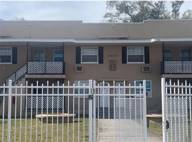 a view of a house with wooden fence