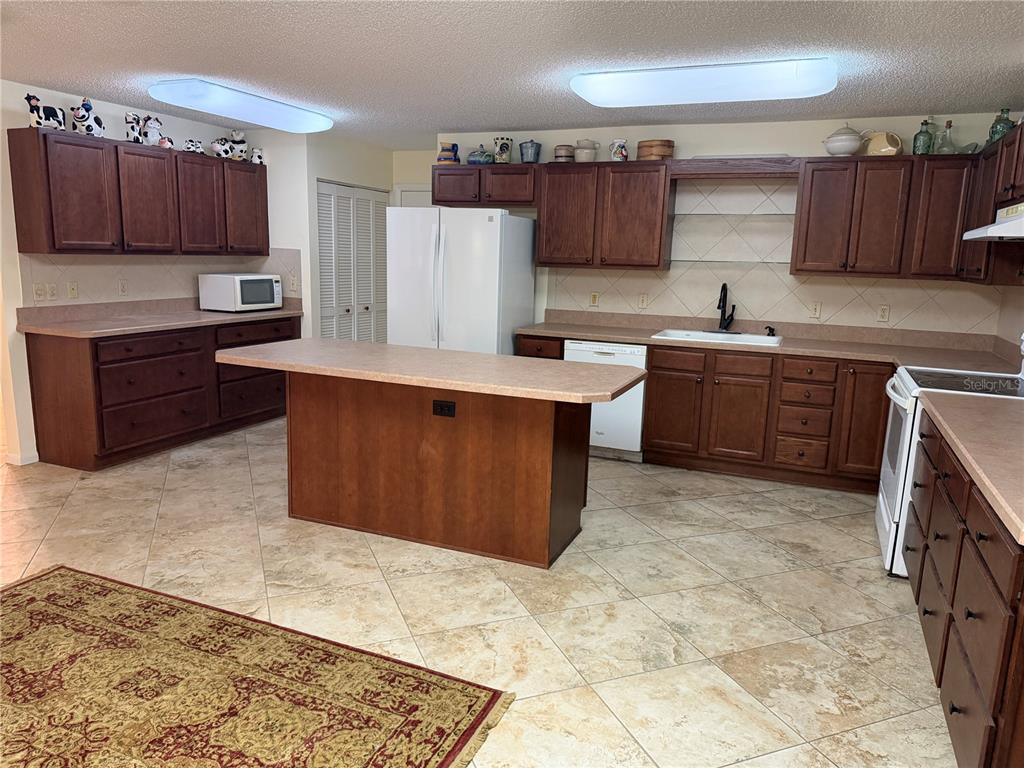 9529 Southwest 85th Avenue, Unit D Ocala, FL 34481 - Photo 5 of 21 a kitchen with stainless steel appliances granite countertop a stove refrigerator sink and cabinets