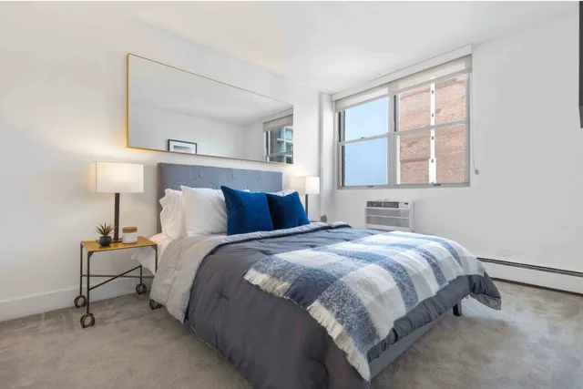 a bedroom with a bed and a lamp