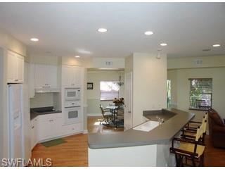 1283 Rainbow Court Naples, FL 34110 - Photo 2 of 8 a kitchen with stainless steel appliances kitchen island granite countertop a refrigerator and a stove