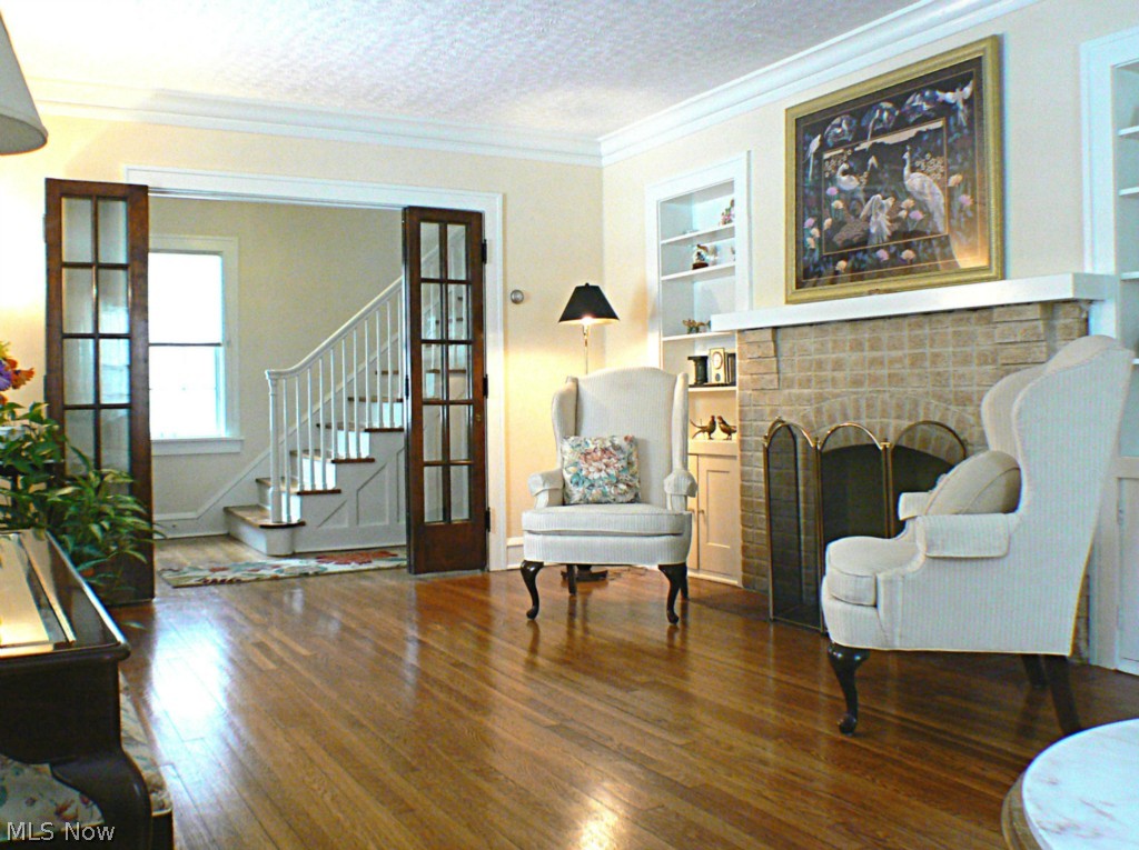 16015 Fernway Road Cleveland, OH 44120 - Photo 4 of 15 Another view of the main/living room with built-in cabinets around the wood burning fireplace