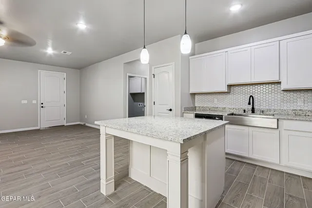 a kitchen with stainless steel appliances granite countertop a sink a stove and a refrigerator