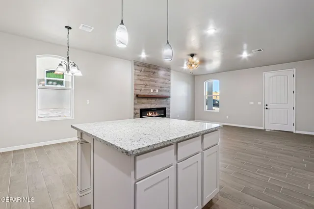 a view of a kitchen island a chandelier and wooden floor