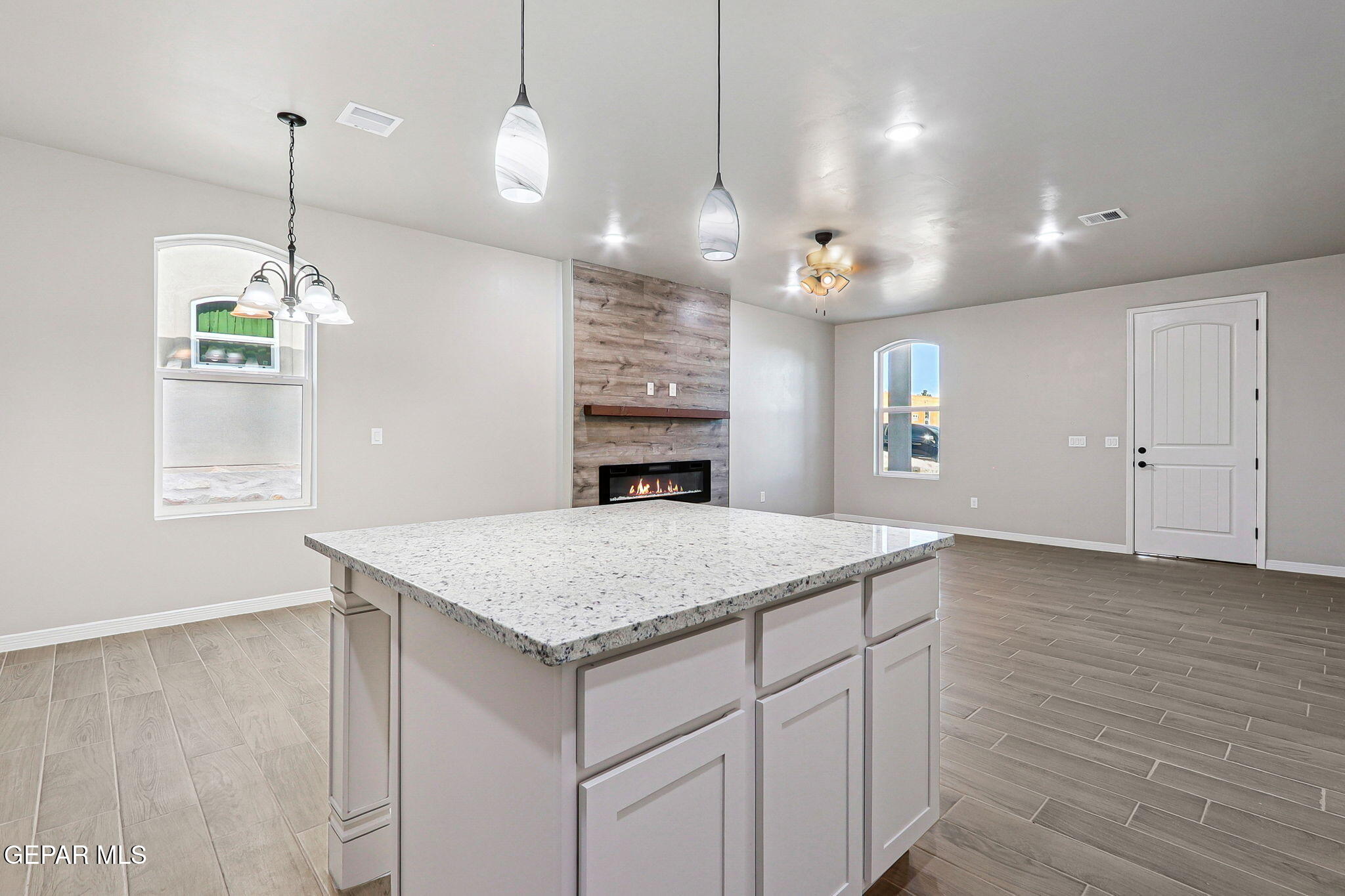 1153 Marquitos Avenue Anthony, NM 88021 - Photo 13 of 40 a view of a kitchen island a chandelier and wooden floor