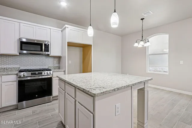 a kitchen with stainless steel appliances granite countertop a sink and microwave