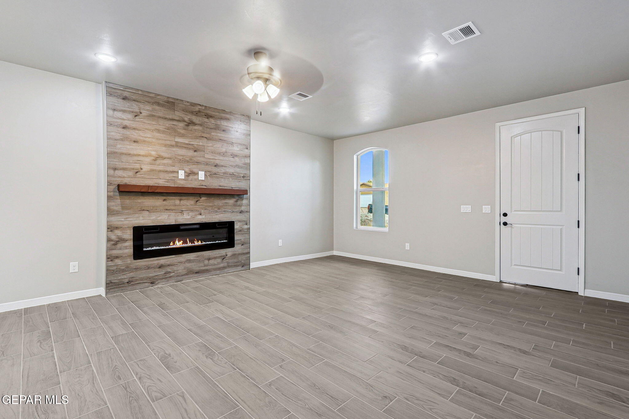 1153 Marquitos Avenue Anthony, NM 88021 - Photo 17 of 40 a view of an empty room with wooden floor fireplace and a window