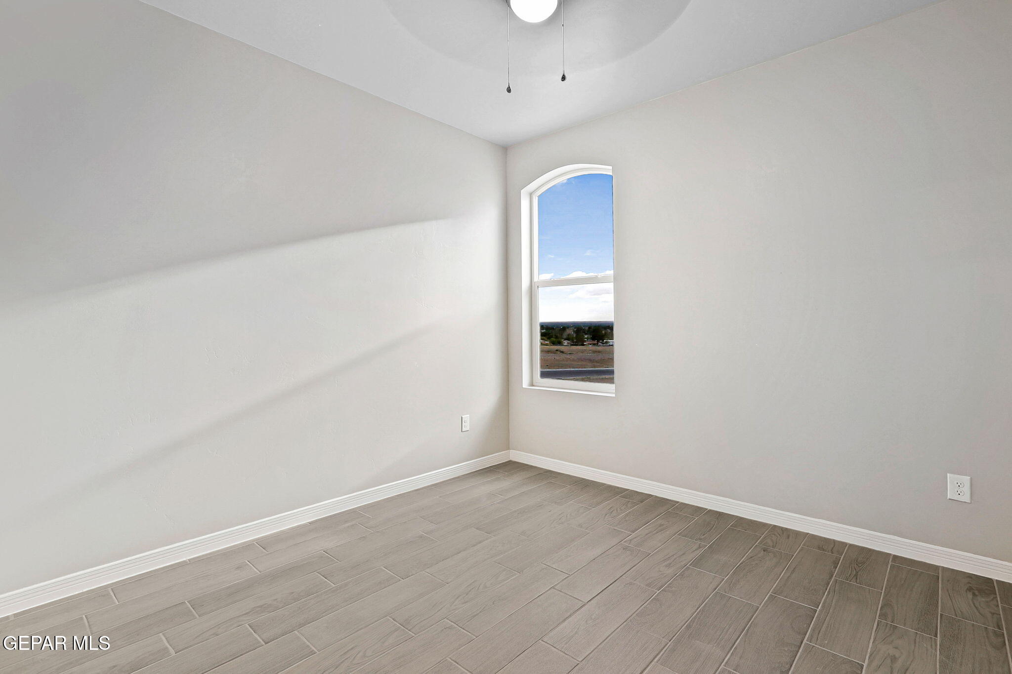 1153 Marquitos Avenue Anthony, NM 88021 - Photo 20 of 40 an empty room with wooden floor and windows