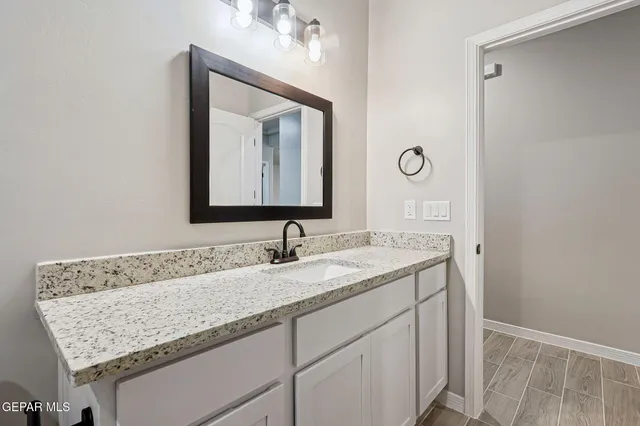 a bathroom with a granite countertop sink and a mirror