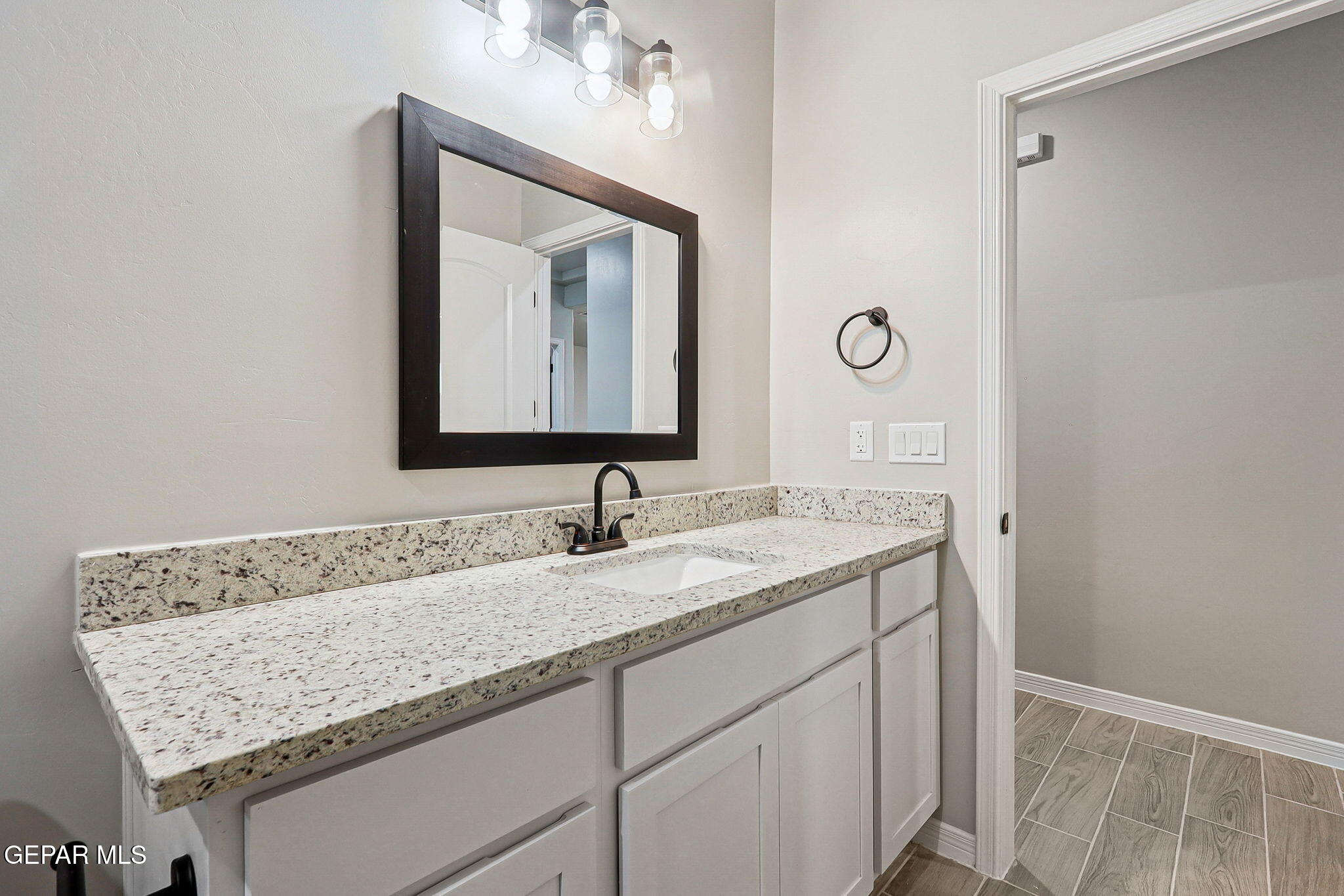 1153 Marquitos Avenue Anthony, NM 88021 - Photo 24 of 40 a bathroom with a granite countertop sink and a mirror