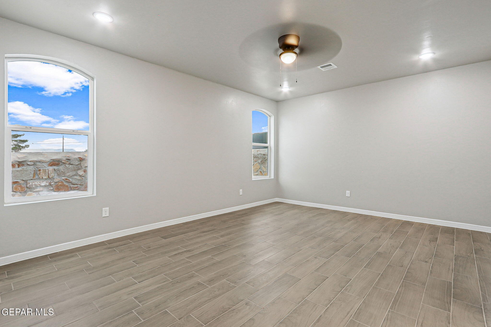 1153 Marquitos Avenue Anthony, NM 88021 - Photo 33 of 40 an empty room with wooden floor and windows