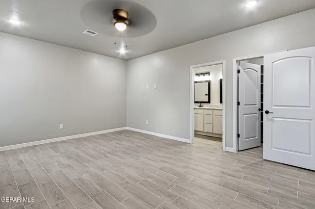 wooden floor in an empty room with a kitchen