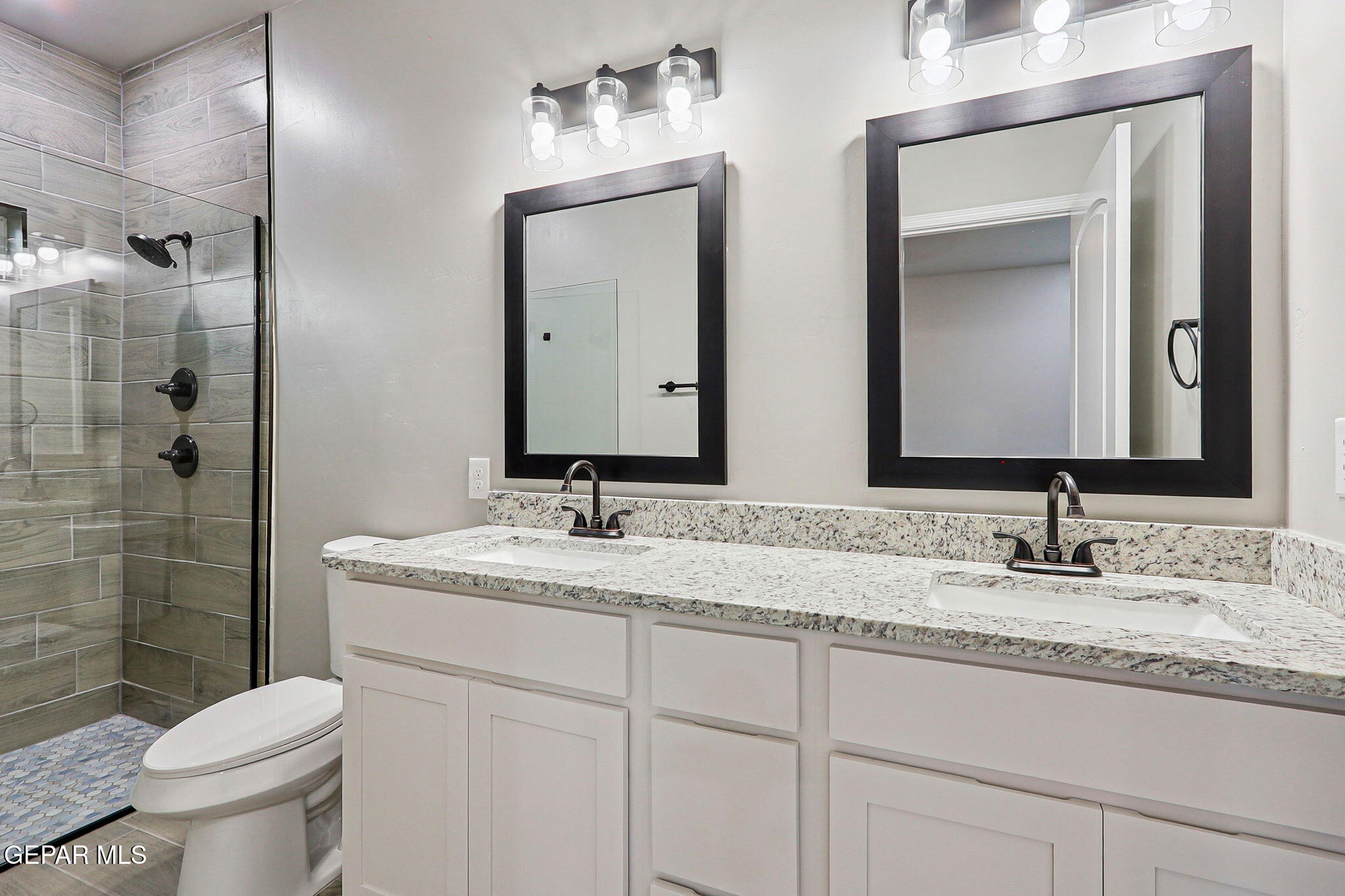 1153 Marquitos Avenue Anthony, NM 88021 - Photo 37 of 40 a bathroom with a granite countertop sink vanity mirror and toilet