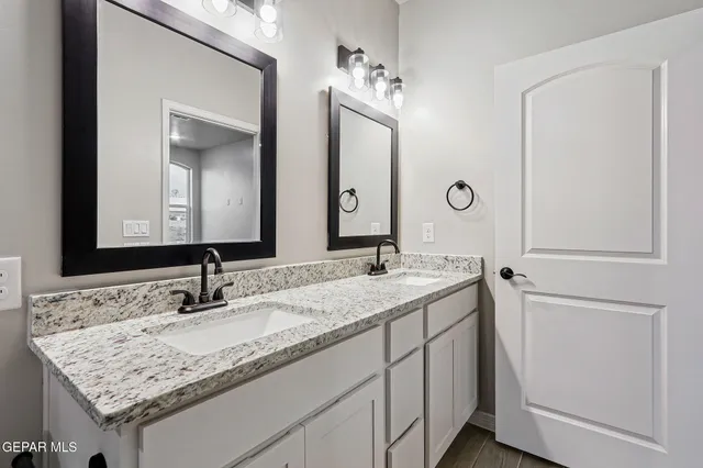 a bathroom with a granite countertop sink and a mirror