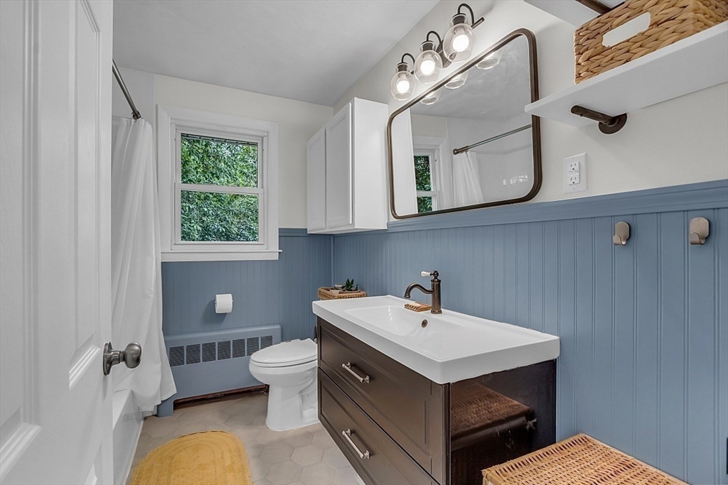 33 Wendover Road Worcester, MA 01606 - Photo 29 of 42 a bathroom with a sink a mirror a toilet and a window
