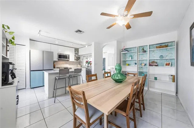 a kitchen with a dining table chairs stainless steel appliances and cabinets