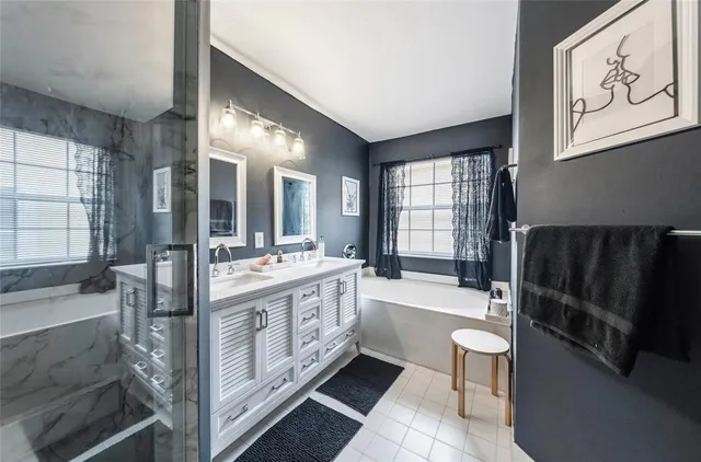 a bathroom with a tub sink and mirror