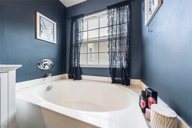 a white bath tub sitting in a bathroom next to a window