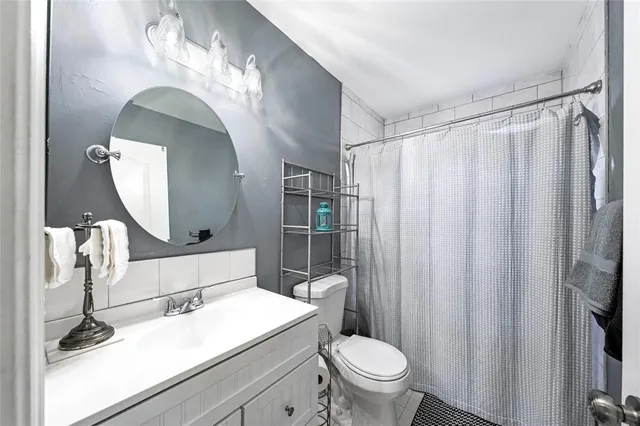 a bathroom with a toilet a sink and mirror