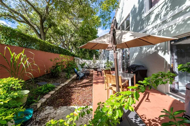 a view of a patio with a table and chairs under an umbrella