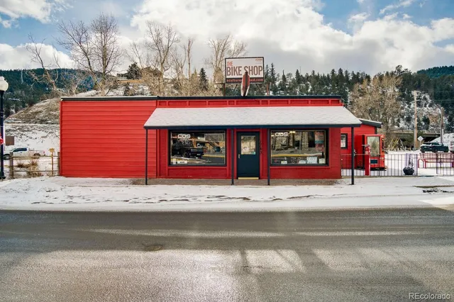a view of a white house with large windows next to a road