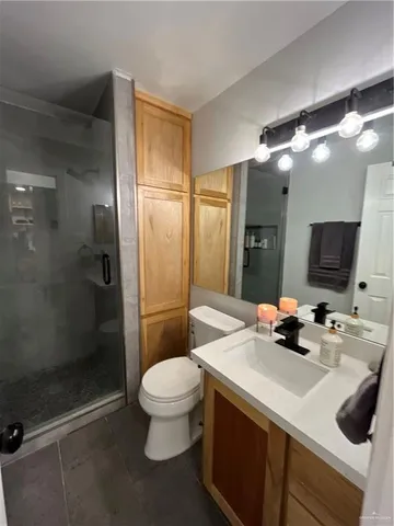 a bathroom with a sink a toilet a mirror and shower
