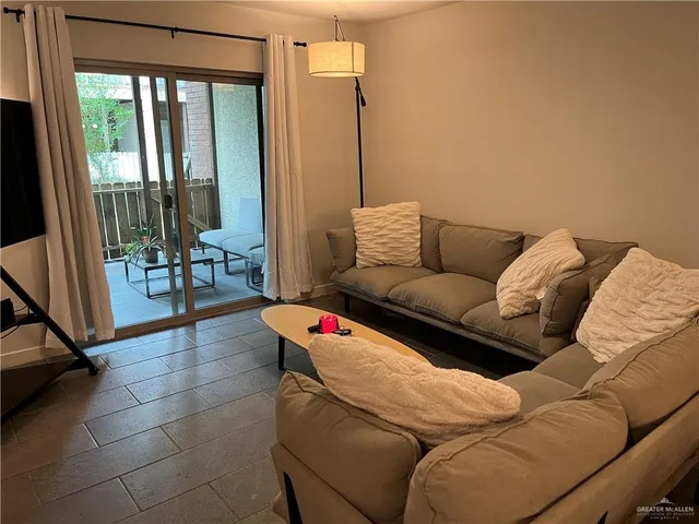 a living room with furniture and a floor to ceiling window