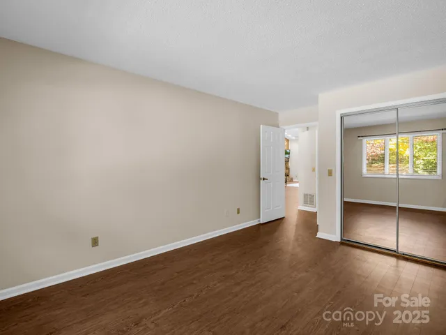 an empty room with wooden floor and window