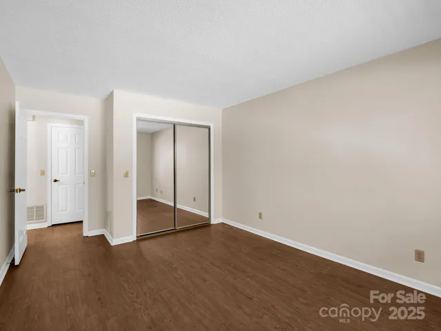 an empty room with wooden floor and door