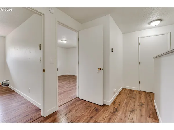 a view of an empty room with wooden floor