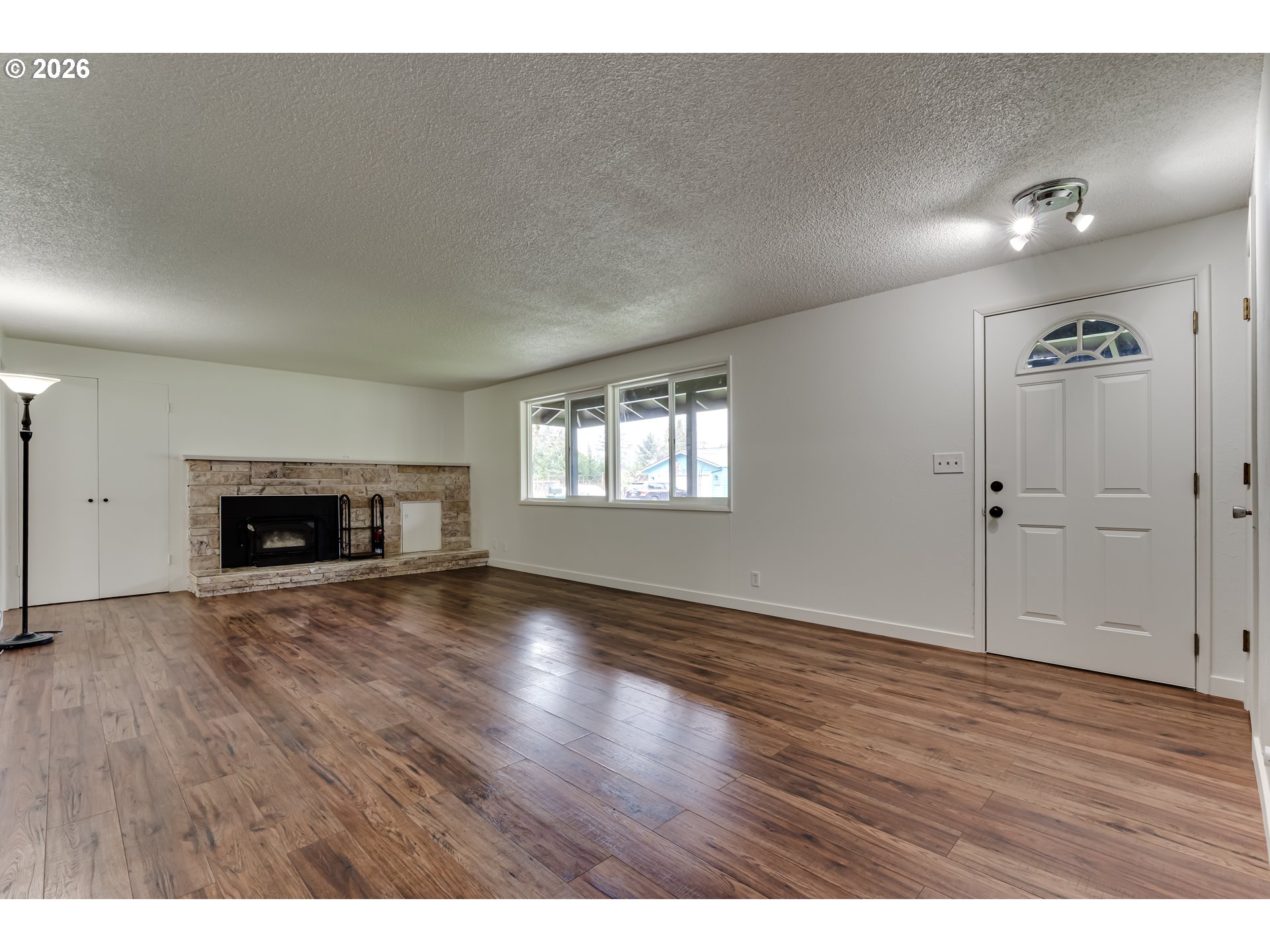 38730 Natures Garden Street Springfield, OR 97478 - Photo 6 of 37 a view of an empty room with wooden floor fireplace and a window