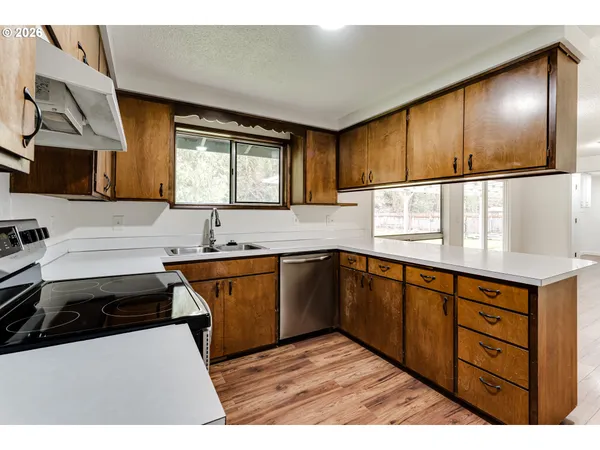 a kitchen with stainless steel appliances granite countertop a sink stove and cabinets